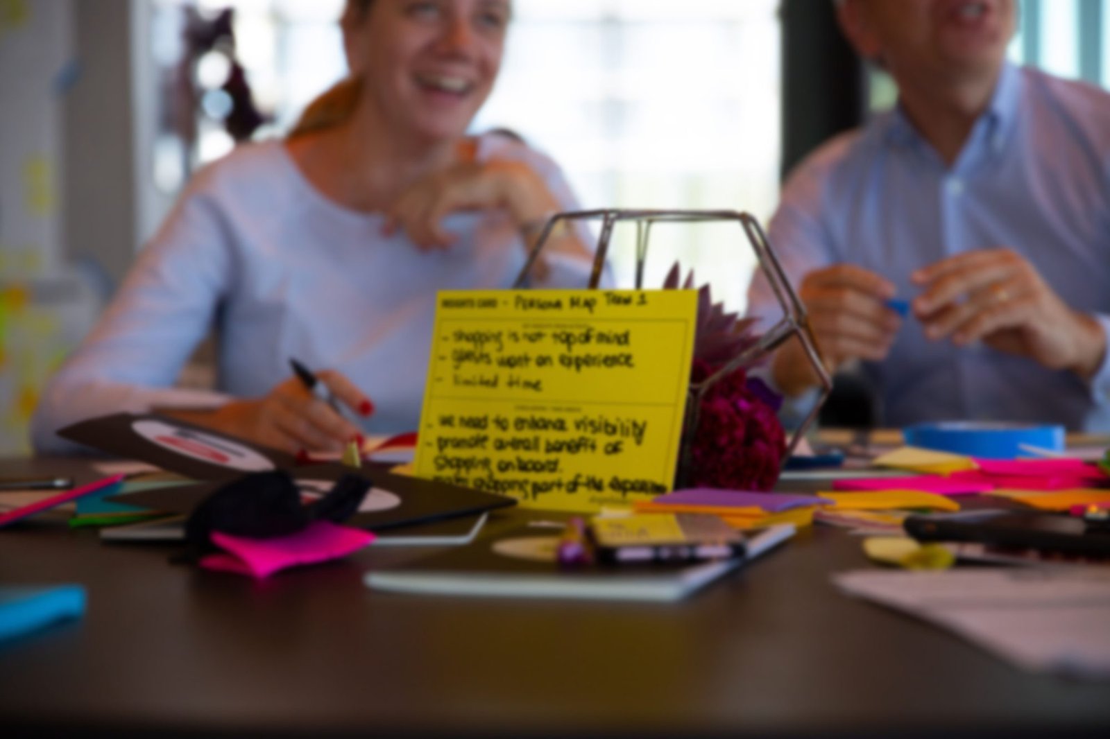 Team members reviewing sticky notes from a customer persona mapping exercise during a co-creation workshop.